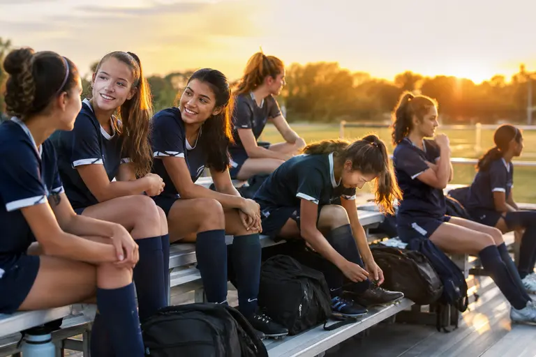 High school girls soccer team preparing for an away match bus trip