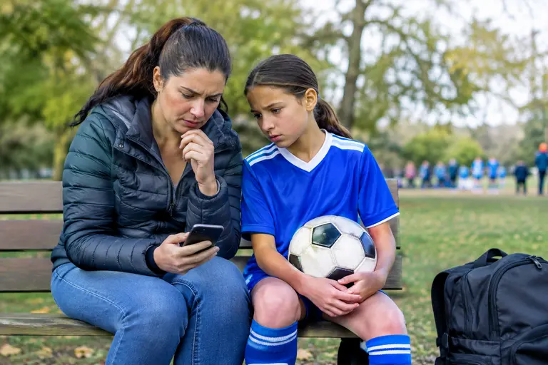 Parents speaking with a youth soccer coach after practice
